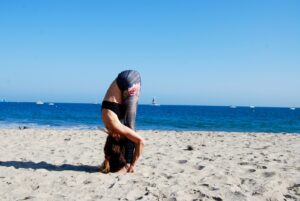 a man doing a handstand on a beach