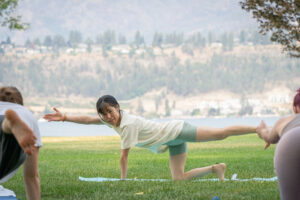 カナダの公園で英語でヨガを指導している